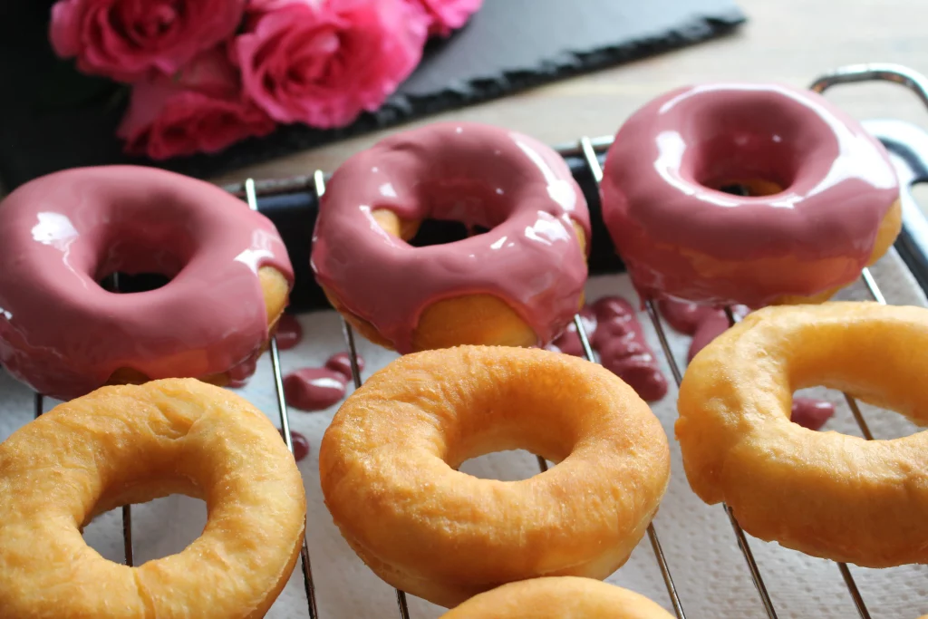 Pour chocolate over donuts